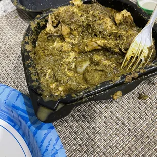 a chicken dish in a pan with a fork