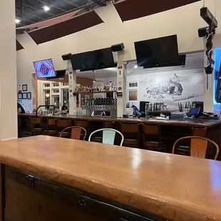 a bar with chairs and a television