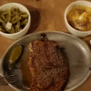a pan of meat with a side of green beans
