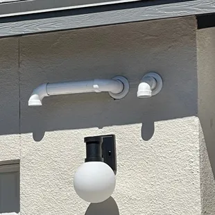 Hot water heater vent? Through the side of the house? Did they maybe forget to vent through the roof? Poor planning on a custom home?