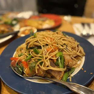 a plate of noodles with meat and vegetables