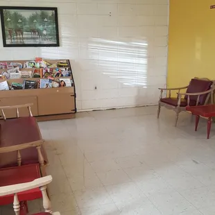 Sitting area has some chairs, a couch, and reading materals