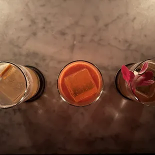 three different cocktails on a table