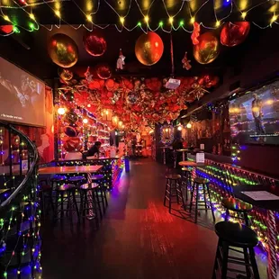 the inside of a bar decorated with christmas lights