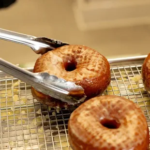 three glazed donuts on a cooling rack