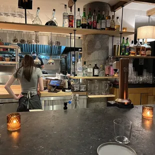 a woman standing at a counter in a restaurant
