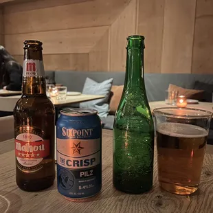 two beer bottles and a glass on a table