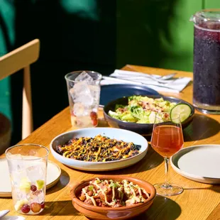 a wooden table with plates of food and drinks