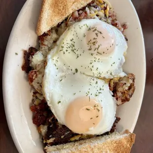 Corned beef hash skillet with basted eggs and white toast