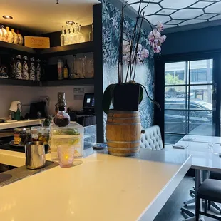 a bar with a vase of flowers on the counter
