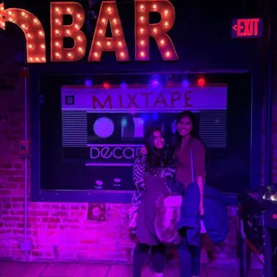 two women standing in front of a bar