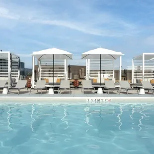 a pool with lounge chairs and umbrellas