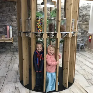 two children playing inside a wooden structure