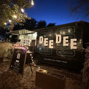 a black food truck parked in a field