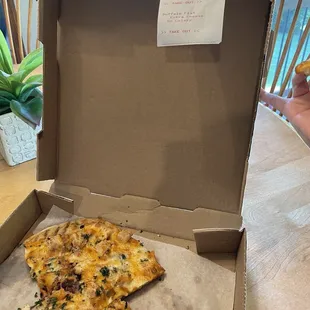 a half eaten pizza in a box