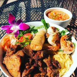 Grilled pork with noodles, lettuce, herbs, shrimp and spring roll.