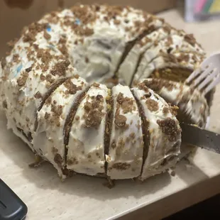a cake with white frosting and brown sprinkles