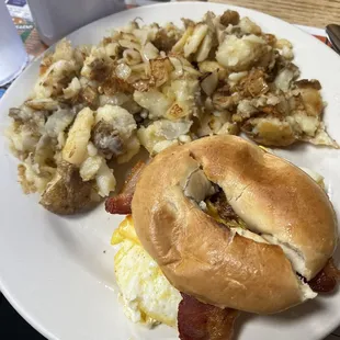 Breakfast sandwich and grilled potatoes with onions