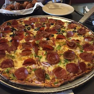 Thin crust with pepperoni, green pepper, onions and black olives on half. Got it well done. So good!!