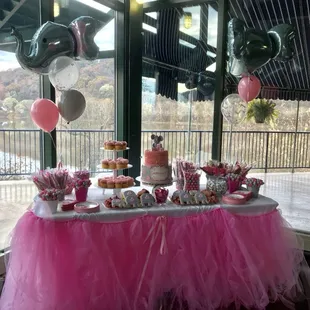 a table with a cake and balloons