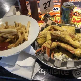 a plate of crab legs and a bowl of fries