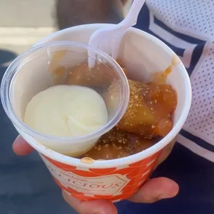 a person holding a cup of ice cream