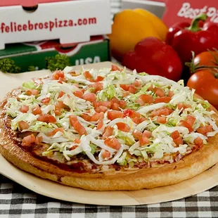 a pizza with tomatoes and lettuce