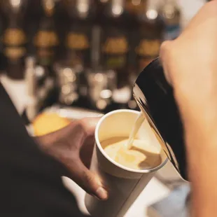 a person pouring coffee into a cup