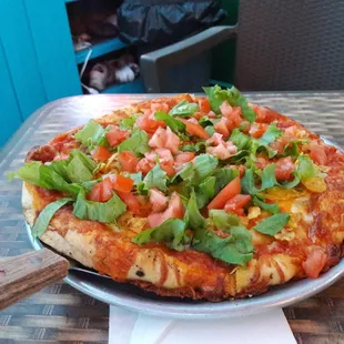 a pizza with tomatoes and lettuce