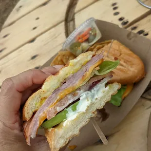 a person holding a sandwich in their hand