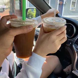 a woman holding a cup of iced coffee