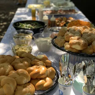 a table full of bagels and other foods