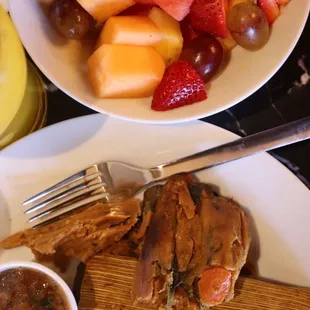 a plate of meat and fruit