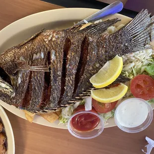 Whole fried fish (tilapia) with salad, and French fries
