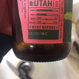 a hand holding a bottle of beer