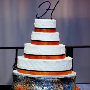 White cake with textured icing and ribbon trim.