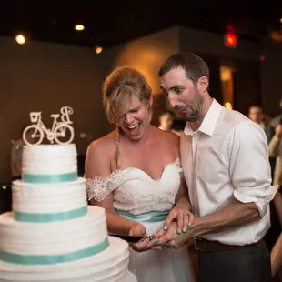 a bride and groom cutting their wedding cake