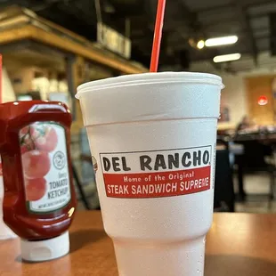 a plastic cup with a straw sitting on a table