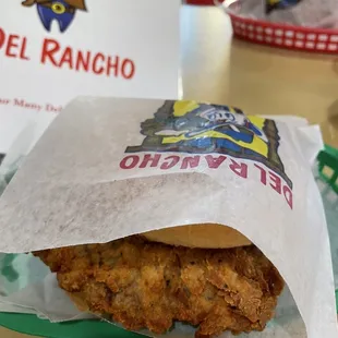 a fried chicken sandwich in a paper bag
