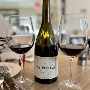 a bottle of tessellae and two glasses of wine