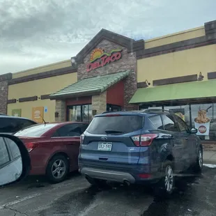 cars parked in front of a del taco restaurant