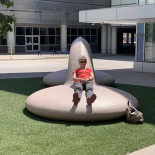 a young boy sitting on a giant chair