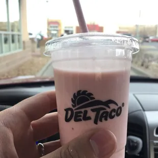 a hand holding a pink drink