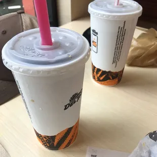 two cups with straws on a table