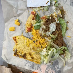 a taco with cheese, lettuce, and other toppings