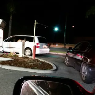 a white car parked in a parking lot at night