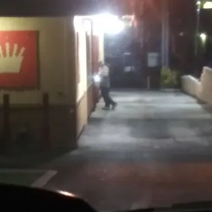 a person walking down a street at night