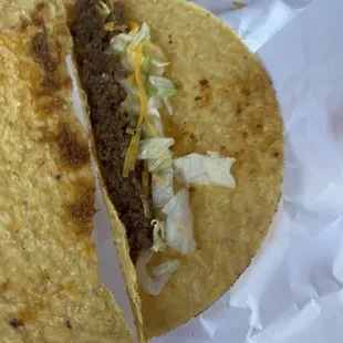 a taco with cheese and lettuce