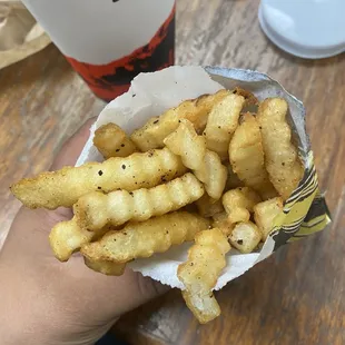 a person holding a basket of french fries
