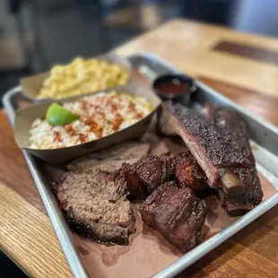 a tray of meat and rice on a table